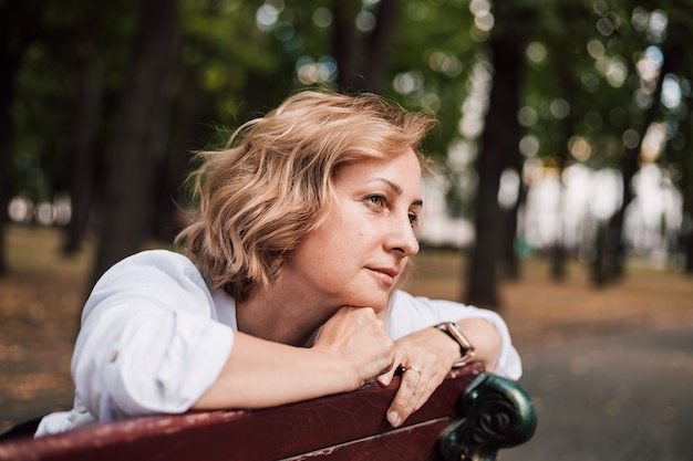 Nadenkend vrouw zitten in het park