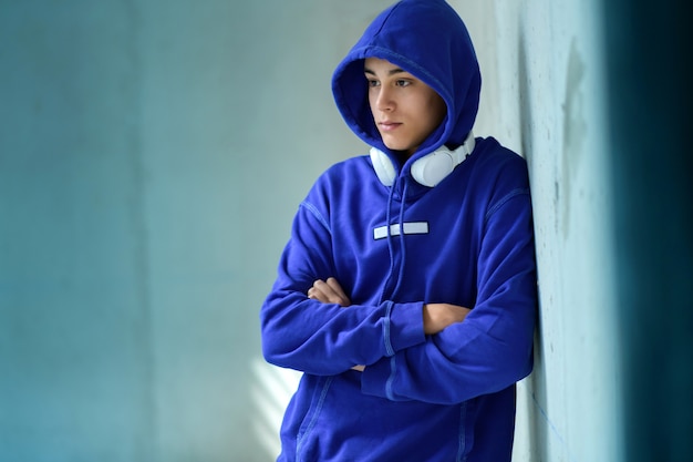 Nadenkende ernstige tiener in een blauwe hoodie