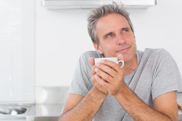 Nadenkende man die koffie in keuken heeft