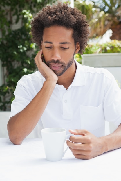 Nadenkende man met een kopje koffie