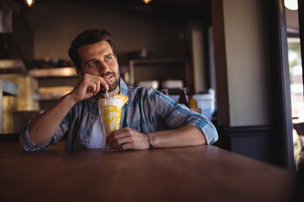 Nadenkende man met milkshake