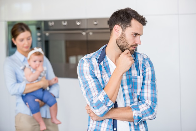 Nadenkende man met vrouw en baby