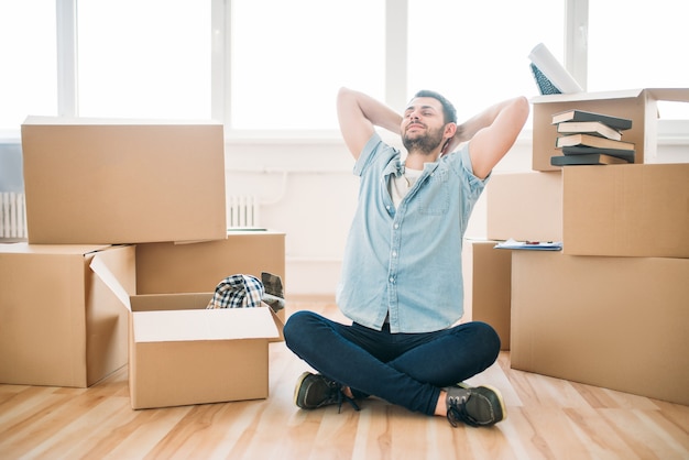 Nadenkende man zit in yoga pose, housewarming