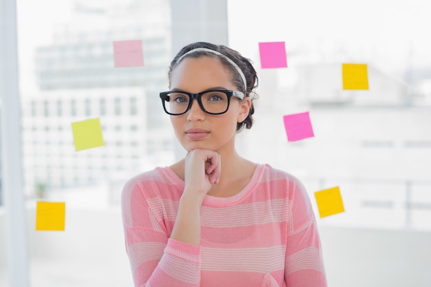 Foto nadenkende vrouw met glazen in creatief bureau