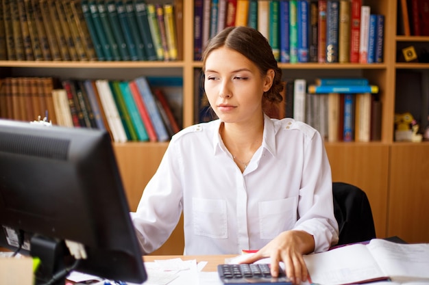 Nadenkende vrouwelijke administratief medewerker die computerlezing controleert