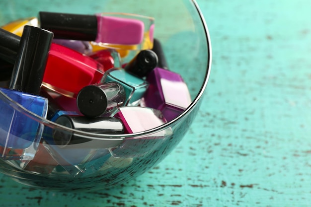 Nagellak in een kom op een houten tafel close-up