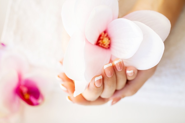 Nagels zorgen. De spijkers van de mooie vrouw met Franse manicure, in schoonheidsstudio