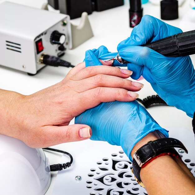 Nagelsalon, handen van cliënt en meester close-up. Nagelbehandeling met een knipper