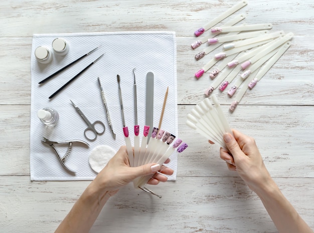 Nail art samples in female hands. Set to create nail design. Nail beauty industry.