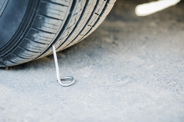 車でアスファルト道路に釘を打ちます。