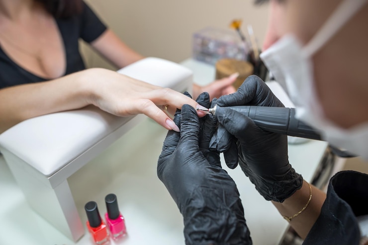 Nail care concept Manicurist makes a manicure to a client girl in a beauty salon