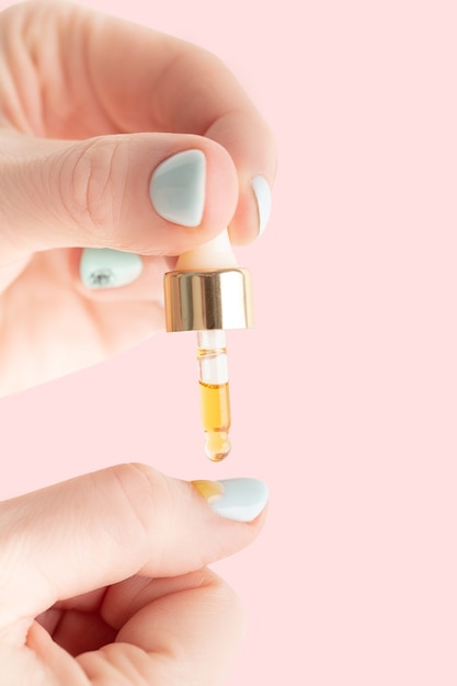 Nail care, a girl drips oil with vitamins on her nails