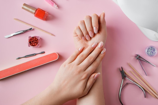 Modern female nude design manicure. Nail care, Self care. Professional  Hardware Manicure. Procedure for the preparation of nails. Cuticle Pusher  Remover. Nail file scissors Stock Photo | Adobe Stock