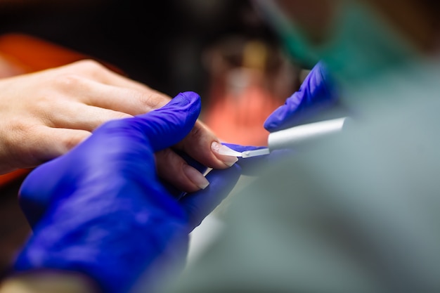 Nail care in salon. Selective focus on costumer's nails