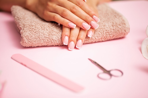 Foto cura delle unghie, donna con belle mani facendo manicure in studio di bellezza