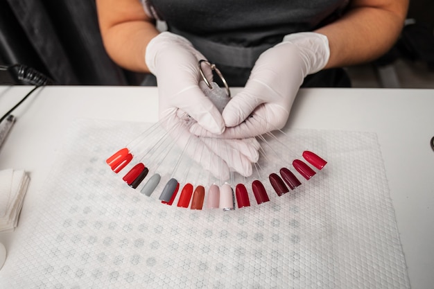 Tavolozza dei colori delle unghie nella donna mani vista dall'alto desktop manicure