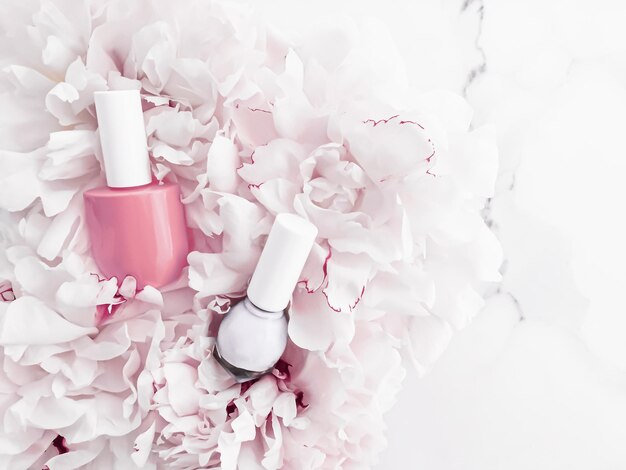 Nail polish bottles on floral background french manicure and cosmetic branding