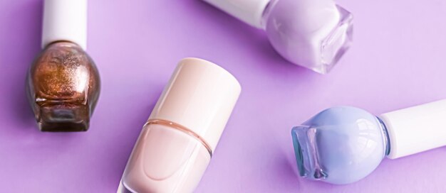 Nail polish bottles on purple background beauty brand