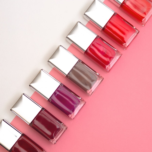 Nail polishes of different colors are built on pink and white background