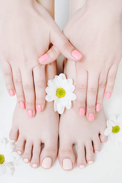 Nail salon. beauty care. manicure pedicure. female hands feet.\
pastel color polish.