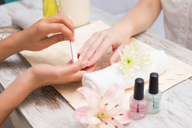 Nail technician giving customer a manicure