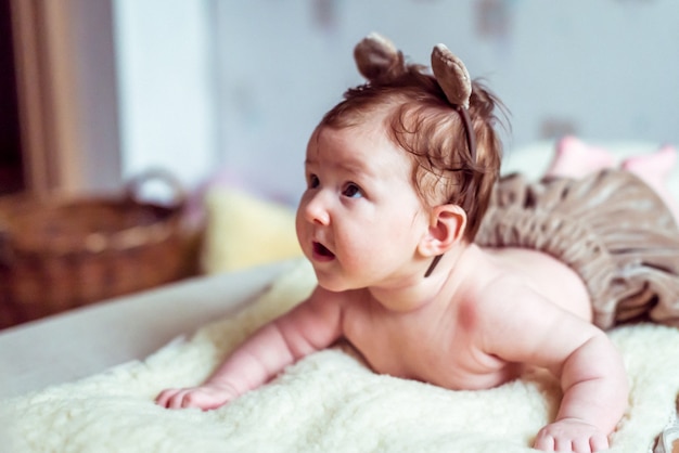 Naked baby lying on blanket