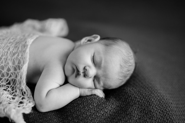 Naked baby sleeps on blanket portrait black and white photo