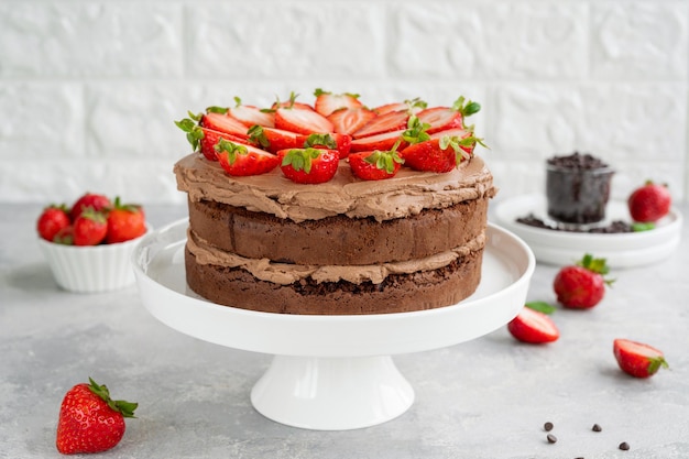 Naked chocolate cake with cream and fresh strawberries on top Rustic style Selective focus