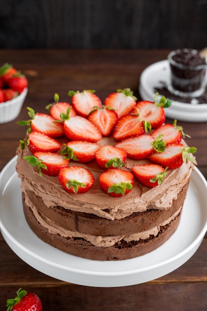 Naked chocolate cake with cream and fresh strawberries on top Selective focus Copy space