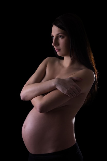 Photo naked pregnant woman isolated on black background