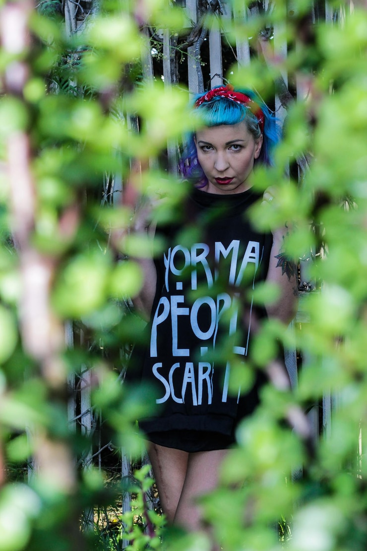 फोटो naked woman holding t-shirt against fence