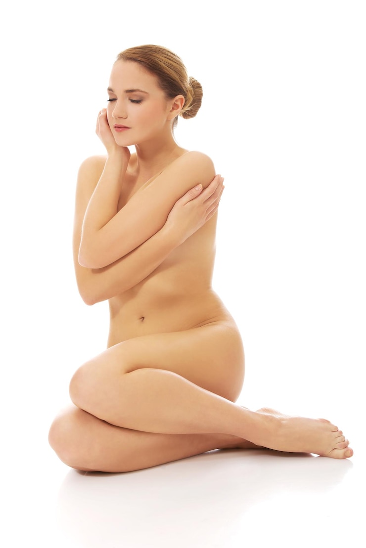 Photo naked young woman sitting over white background