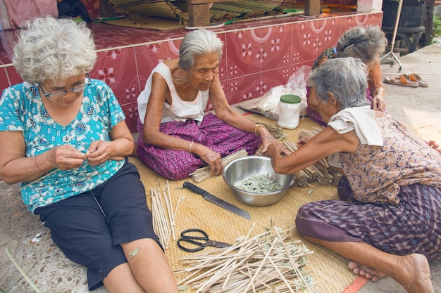 ナコンファノム、タイ -  2019年3月25日：グループ年配の女性が手動で竹を織ります。