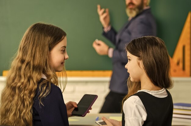 Foto naleving van het internetbeleid van de school internet surfen op sociale netwerken probleem van smartphones op scholen in plaats van studeren schoolstudenten en leraar verslaafd aan online games op internet