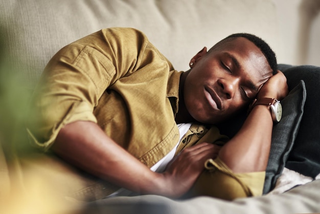 Nap if you can its good for you Cropped shot of a handsome young man sleeping on the couch in his living room at home