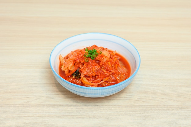 Napa cabbage kimchi in white bowl of side dishes