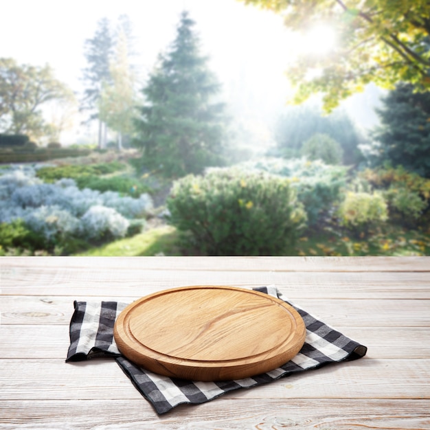 Photo napkin and board for pizza on wooden desk. summer landscape.