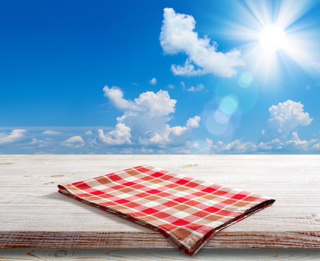 Napkin on wooden table perspective. Summer landscape.