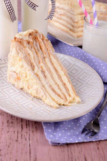 Napoleon cake with milk on table closeup