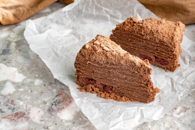 Napoleoncake met vla is versierd met kersen en geraspte chocolade op tafel