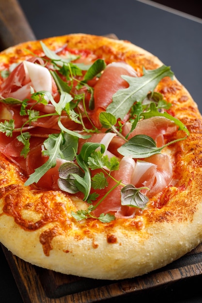 Napoli pizza with herbs on wooden cutting board