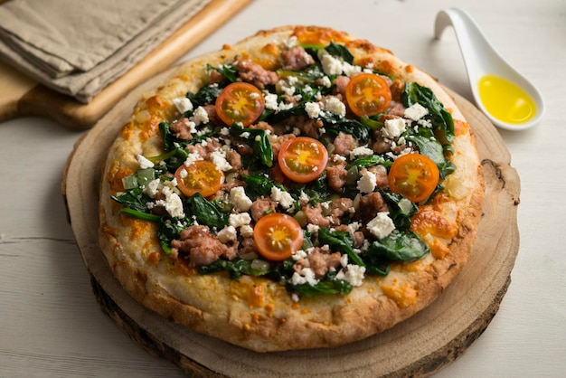 Foto napolitaanse pizza met worst en spinazie.