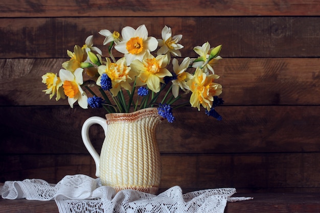 Narcissen in een kruik op de tafel. boeket tuinbloemen