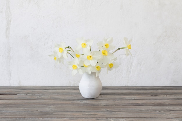 Narcissus in vase on wooden table