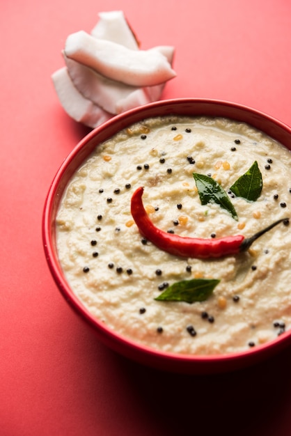 Nariyal of Coconut Chutney geserveerd in een kom. Geïsoleerd over humeurige achtergrond. selectieve focus