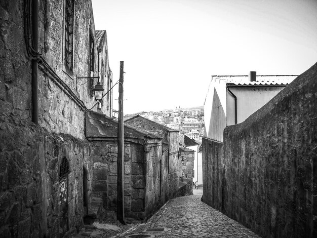 Foto stretto vicolo in mezzo agli edifici contro il cielo