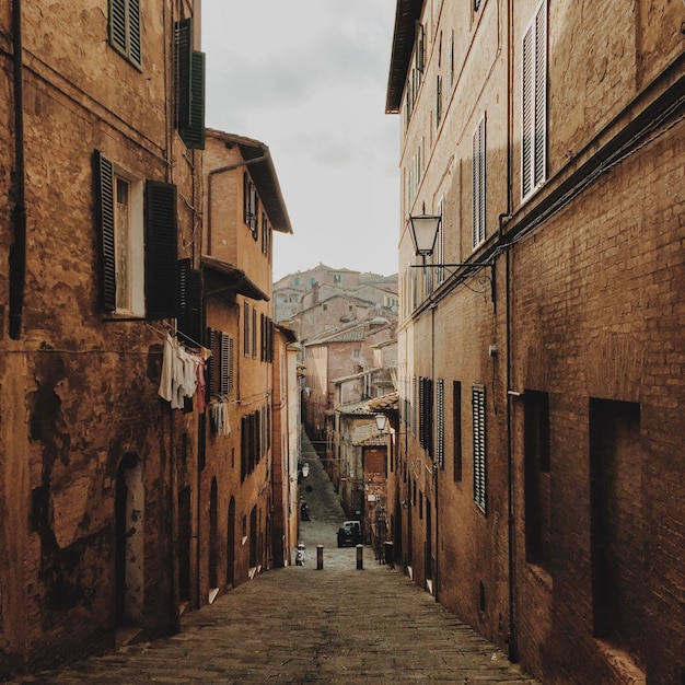 Foto stretto vicolo in mezzo a residenze storiche a siena