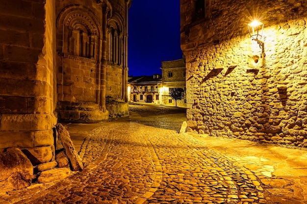 Narrow alley lit up at night with street lamps. Santillana del Mar, Santander.