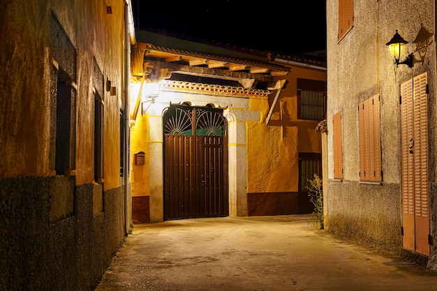 Narrow alley of old houses at night in village of spain.