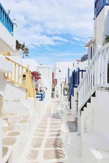 Photo a narrow alley with a white house and blue shutters